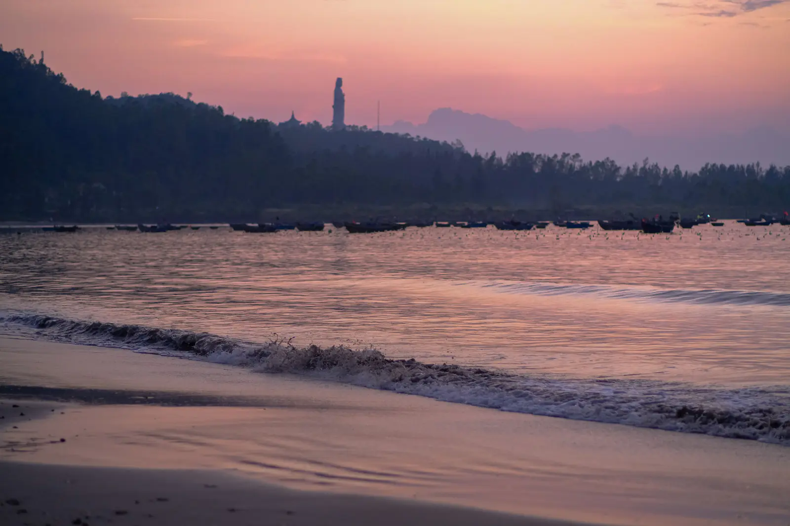 Bình minh trên bãi biển Mỹ Khê, thuyền thúng ngoài xa và tượng Phật Bà trên bán đảo Sơn Trà